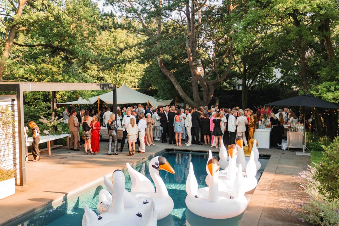 Zomerse borrel in een tuin met gasten rond het zwembad