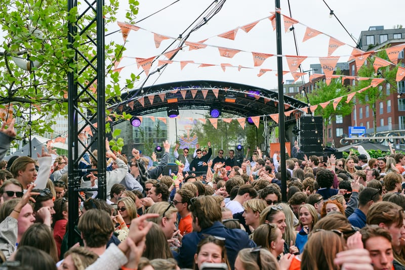 Publiek voor een festivalpodium met vlaggenlijnen